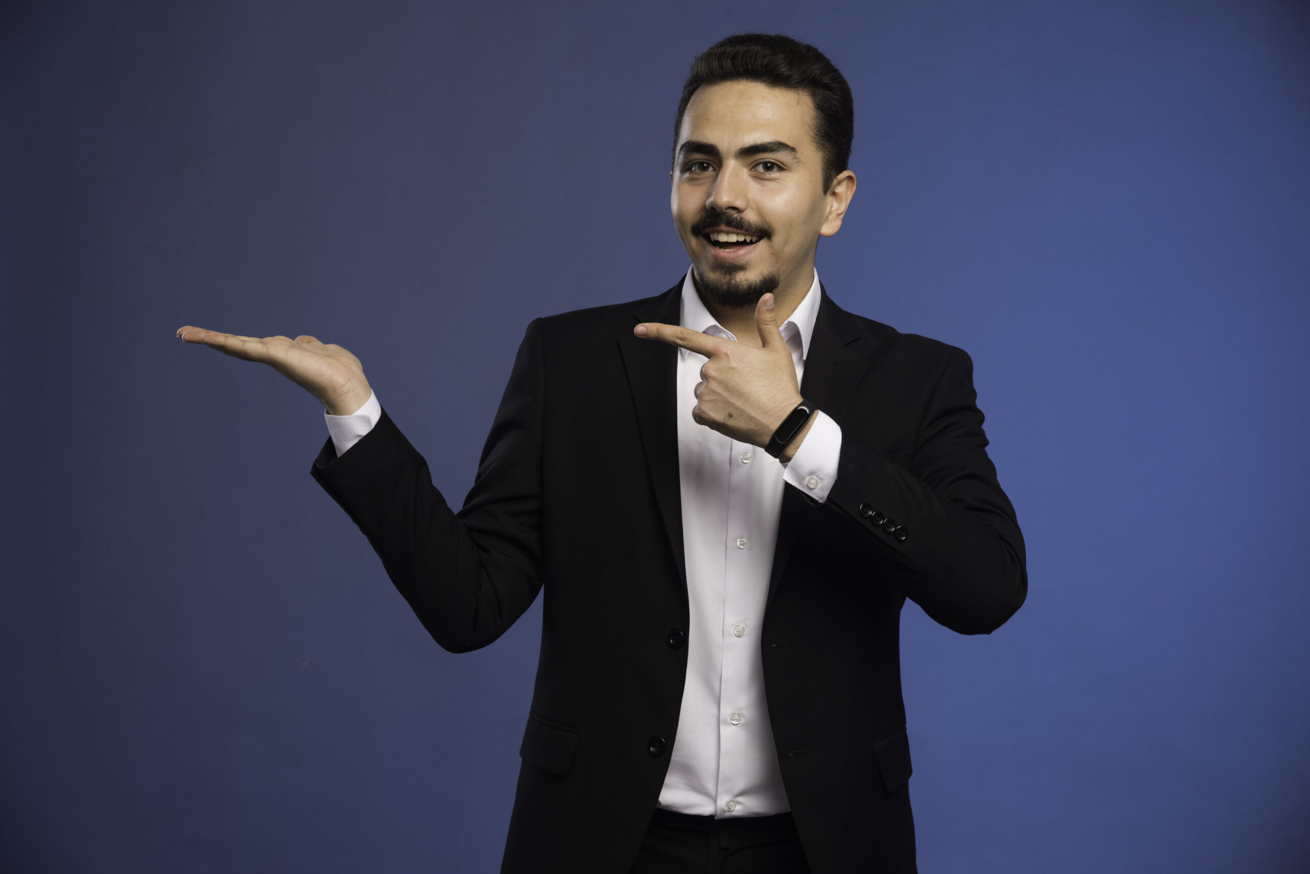 Businessman in black suit pointing to something. High quality photo